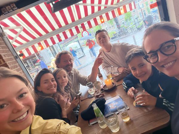 This lively photo captures a group of people enjoying drinks and conversation at a cafe on Staalstraat, Centrum, Amsterdam
